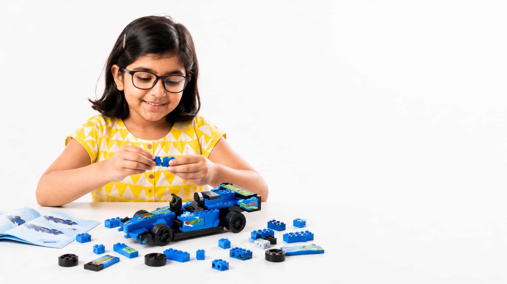 A girl assembling a ThinkerPlace building-block race car kit